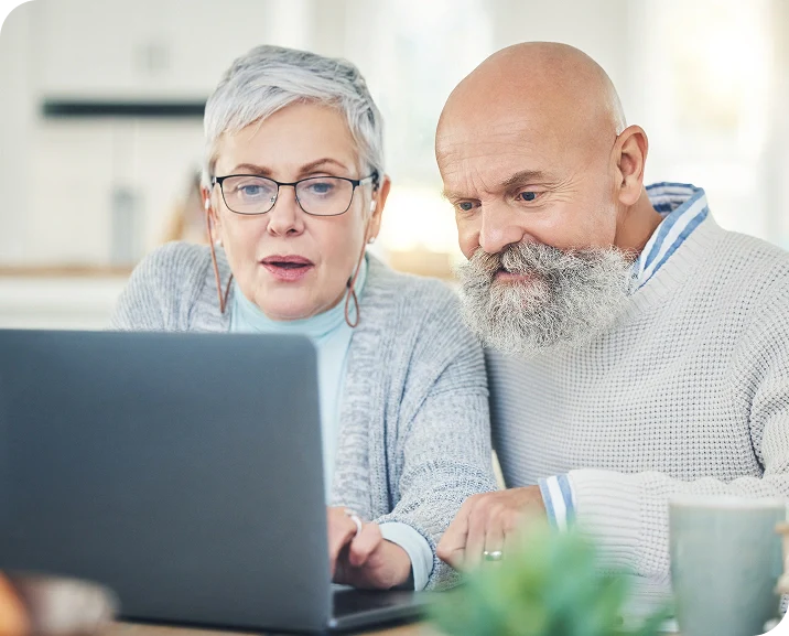 Elderly couple reviewing their benefits on a laptop
